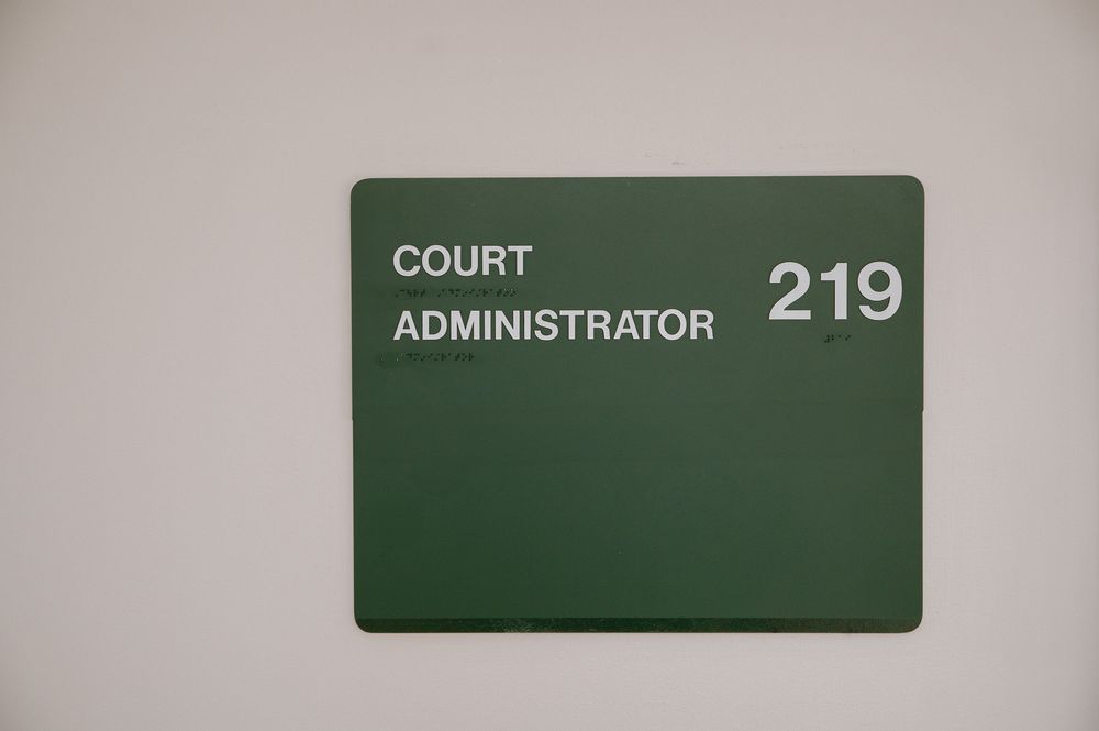 Signs in a hallway show numbers 219 and 218 with text identifiers mounted on a wall.