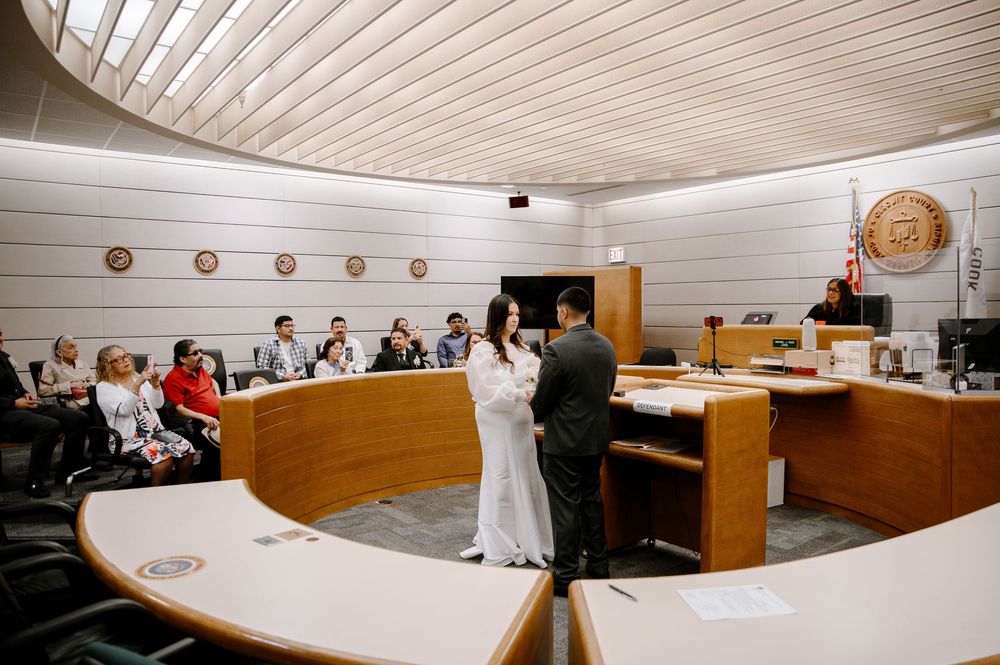 Modern courthouse interior with wood paneling and white ceiling showing multiple viewing angles of a courtroom.