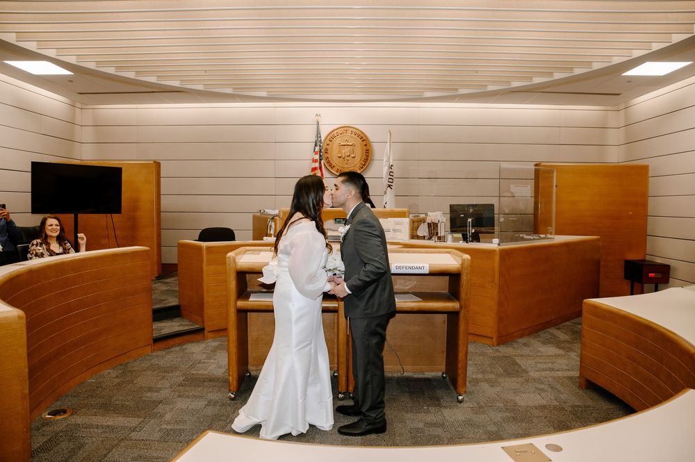A simple ceremony room with wooden benches and white-painted horizontal panels lining the walls.