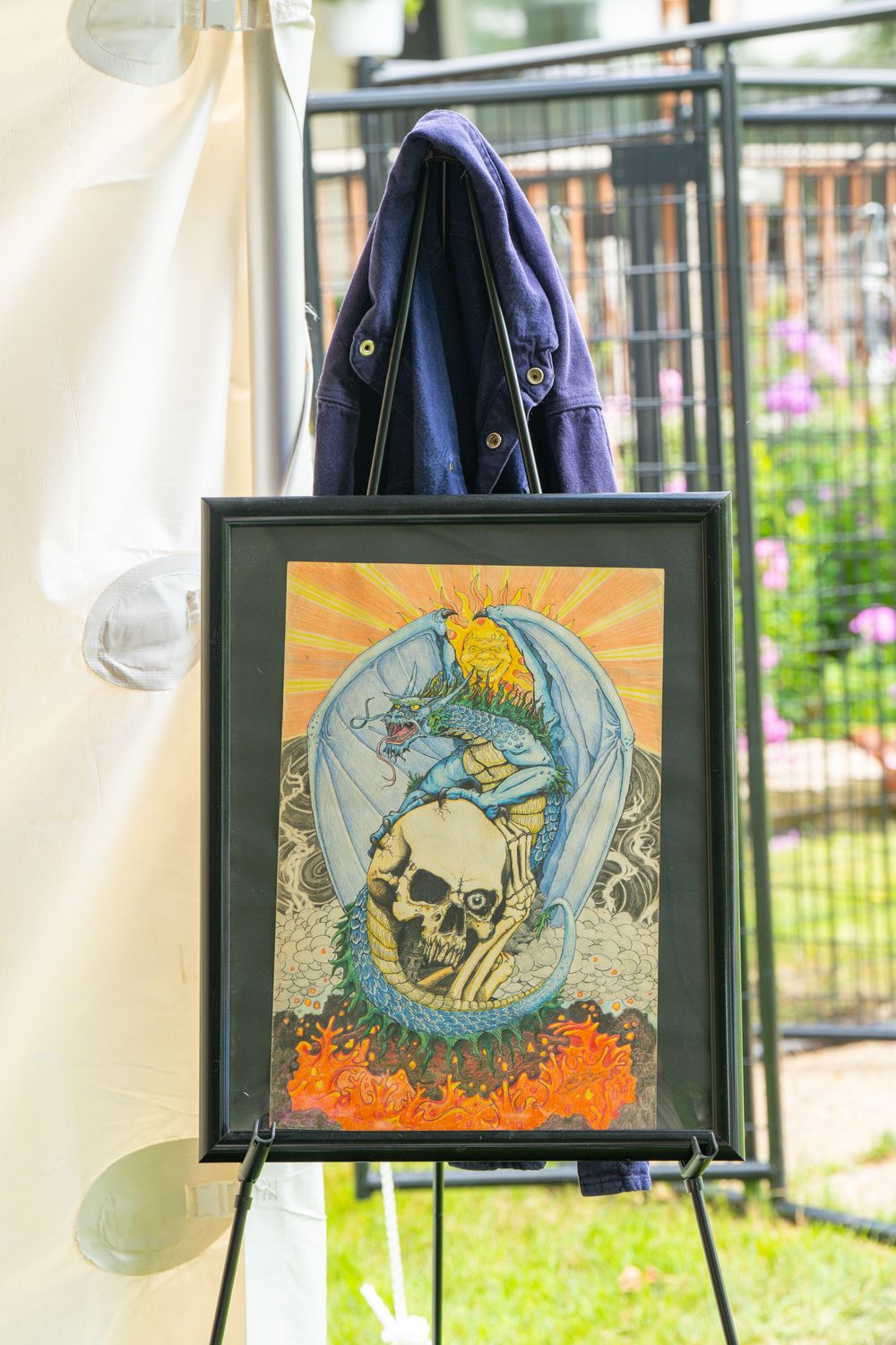 Artistic skull and angel artwork displayed in black frames at an outdoor exhibition. Celebration of Life Quad Cities Photography