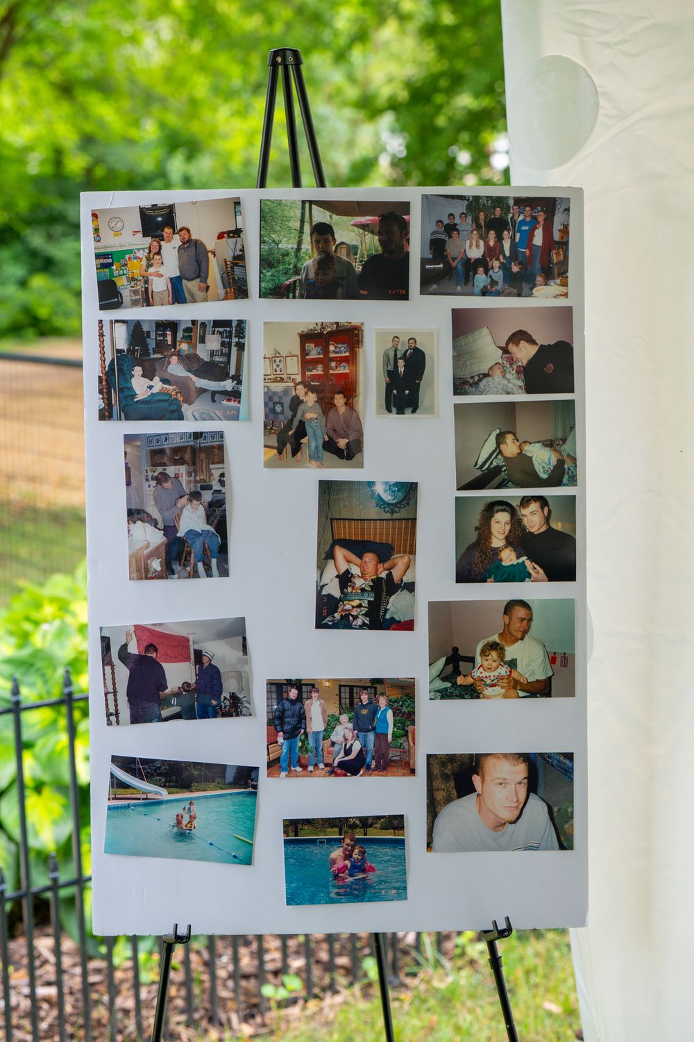 Photo display boards showing vintage family photographs mounted outdoors against a green natural background. Celebration of Life Quad Cities
