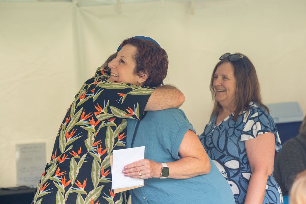 Two people sharing an emotional embrace with happy smiles and laughter in an indoor setting. Celebration of Life Quad Cities Photography