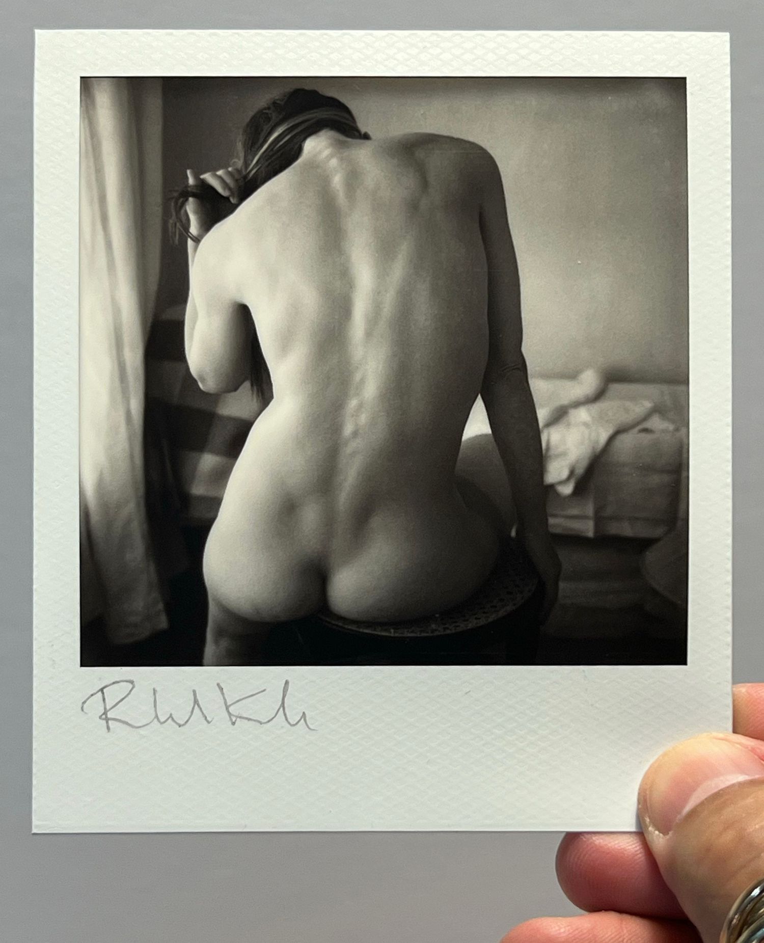 Artistic black and white polaroid of a turned back in natural light.