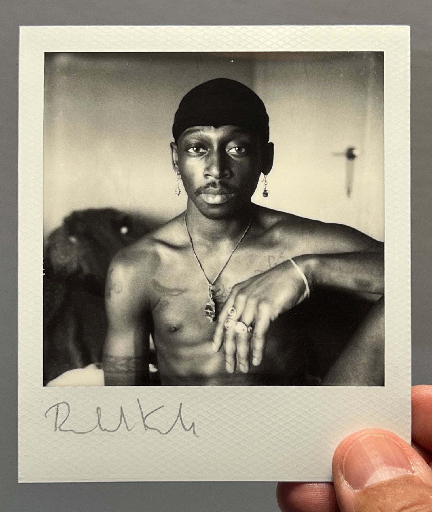 Dramatic black and white portrait photograph in polaroid format showing artistic expression.