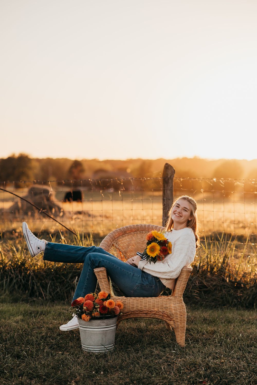 Golden sunset scene with wicker chair, sunflowers and pumpkins in rustic outdoor setting at harvest time.