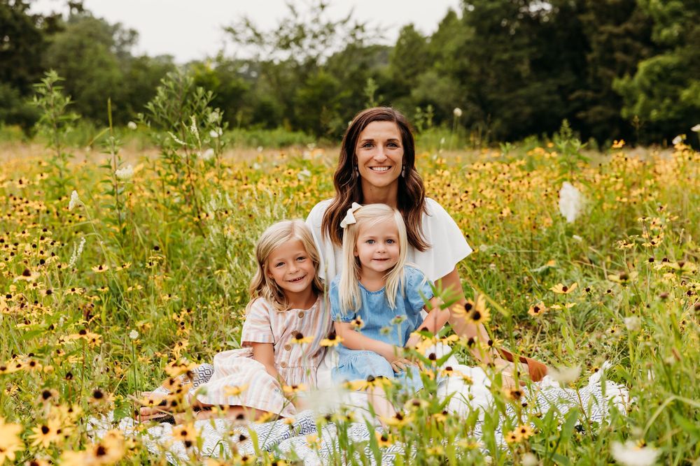 Happy family moment captured in a sun-drenched field of yellow wildflowers.