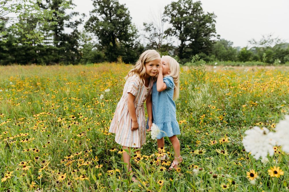 Sweet interactions between children in a summer meadow filled with yellow blooms.
