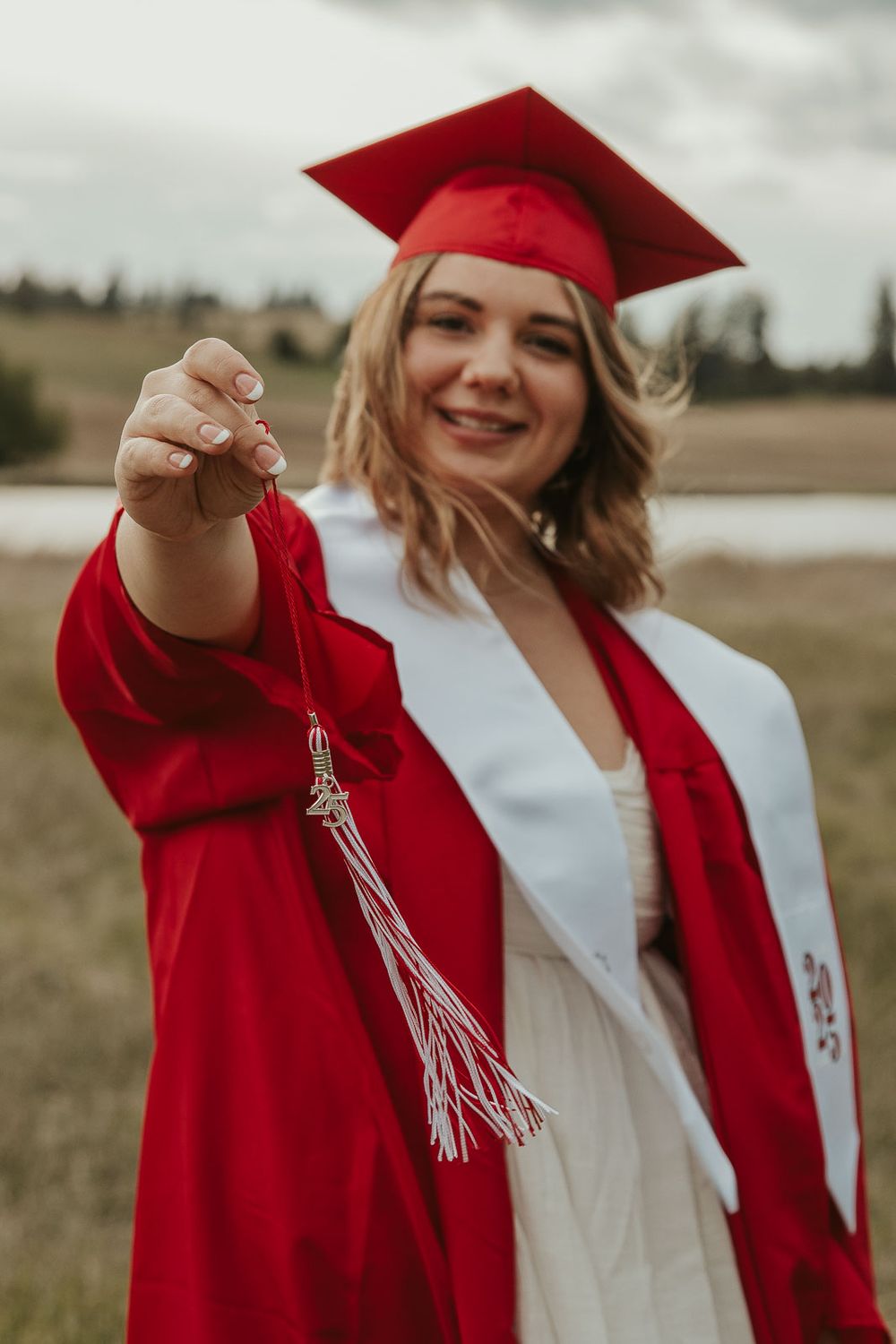 Graduation portraits in natural light with scenic countryside background. Cap and gown photo session for senior girl near Spokane WA