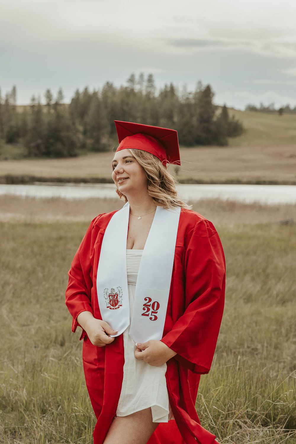 Graduation portraits in natural light with scenic countryside background. Cap and gown photo session for senior girl near Spokane WA