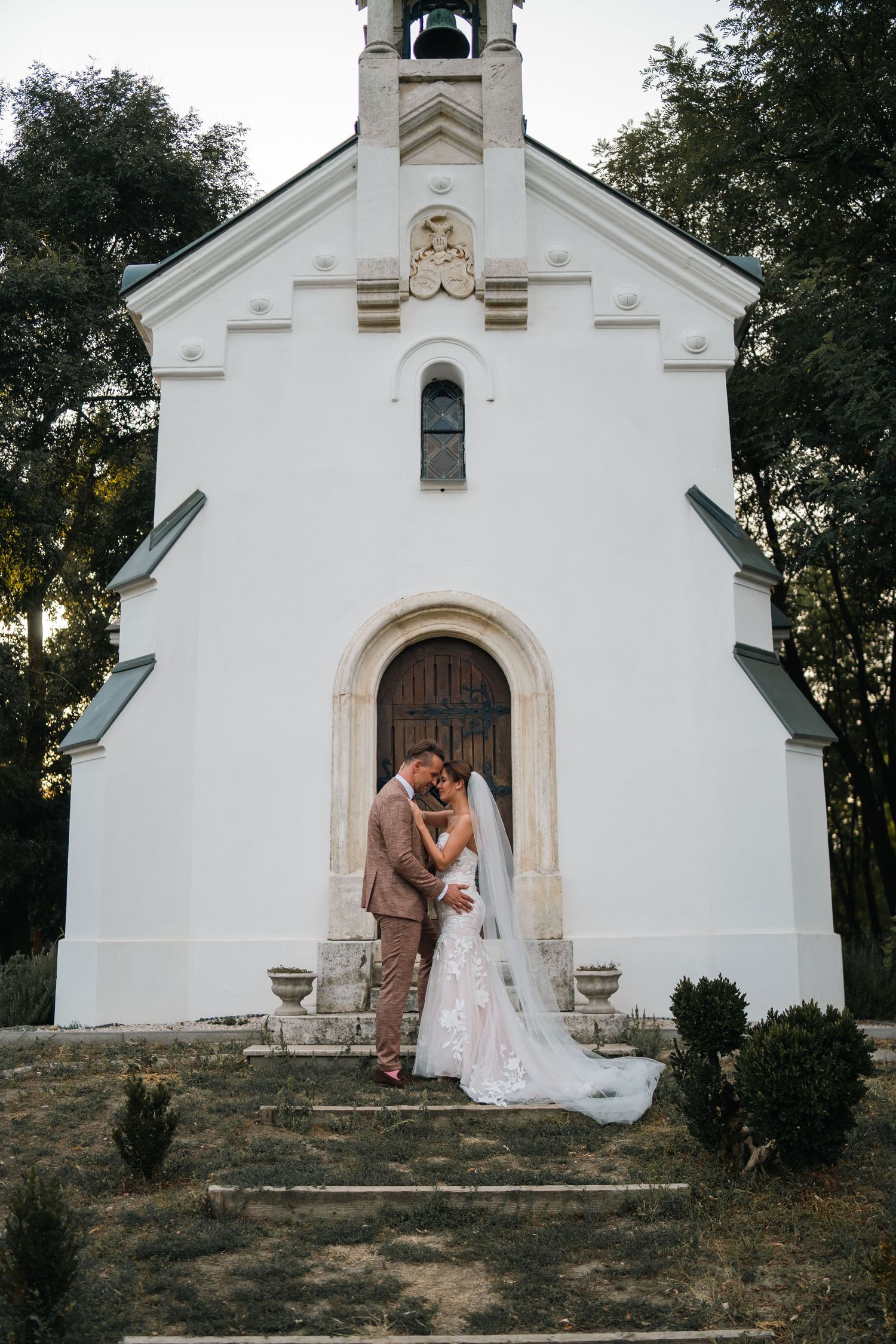 Bride in a flowing white veil gazes to the side during a wedding portrait session.