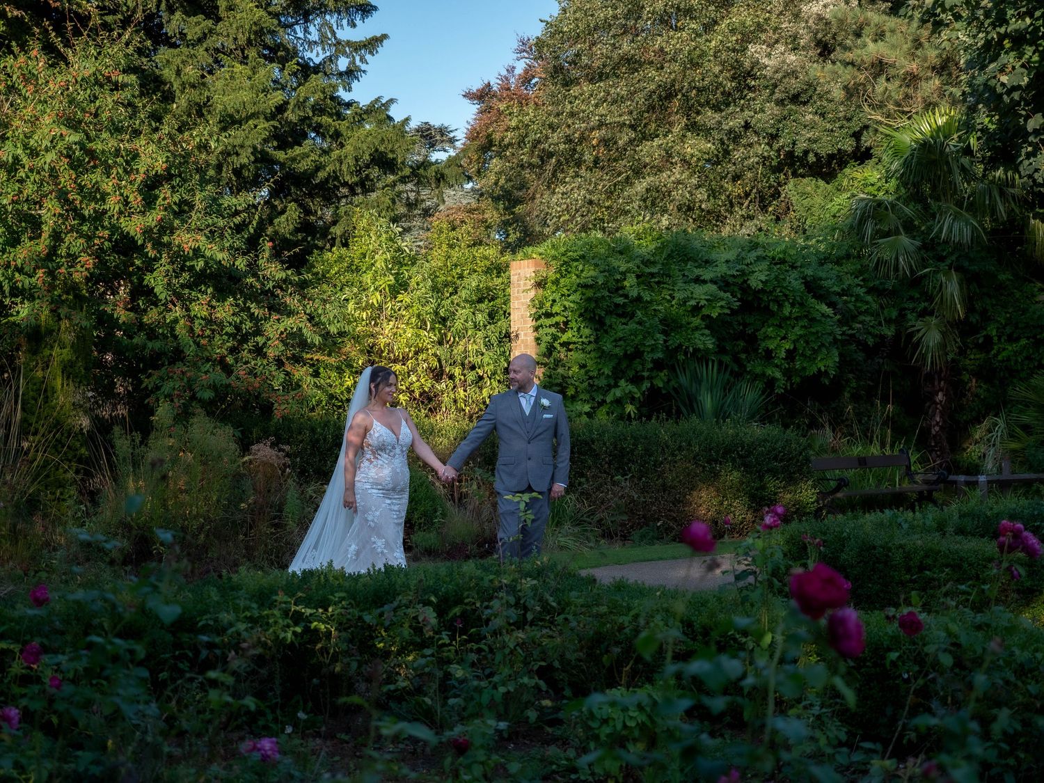 Bride and groom walking through the rose garden at Arnot hill venue nottingham