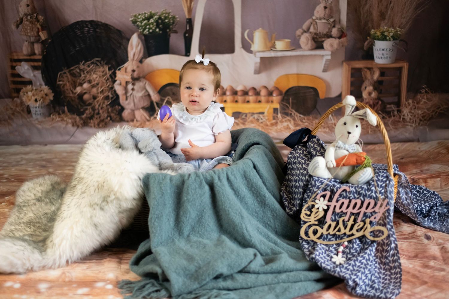 Cozy Easter-themed studio setup with plush bunnies, rustic decorations, and teal blanket on floor.