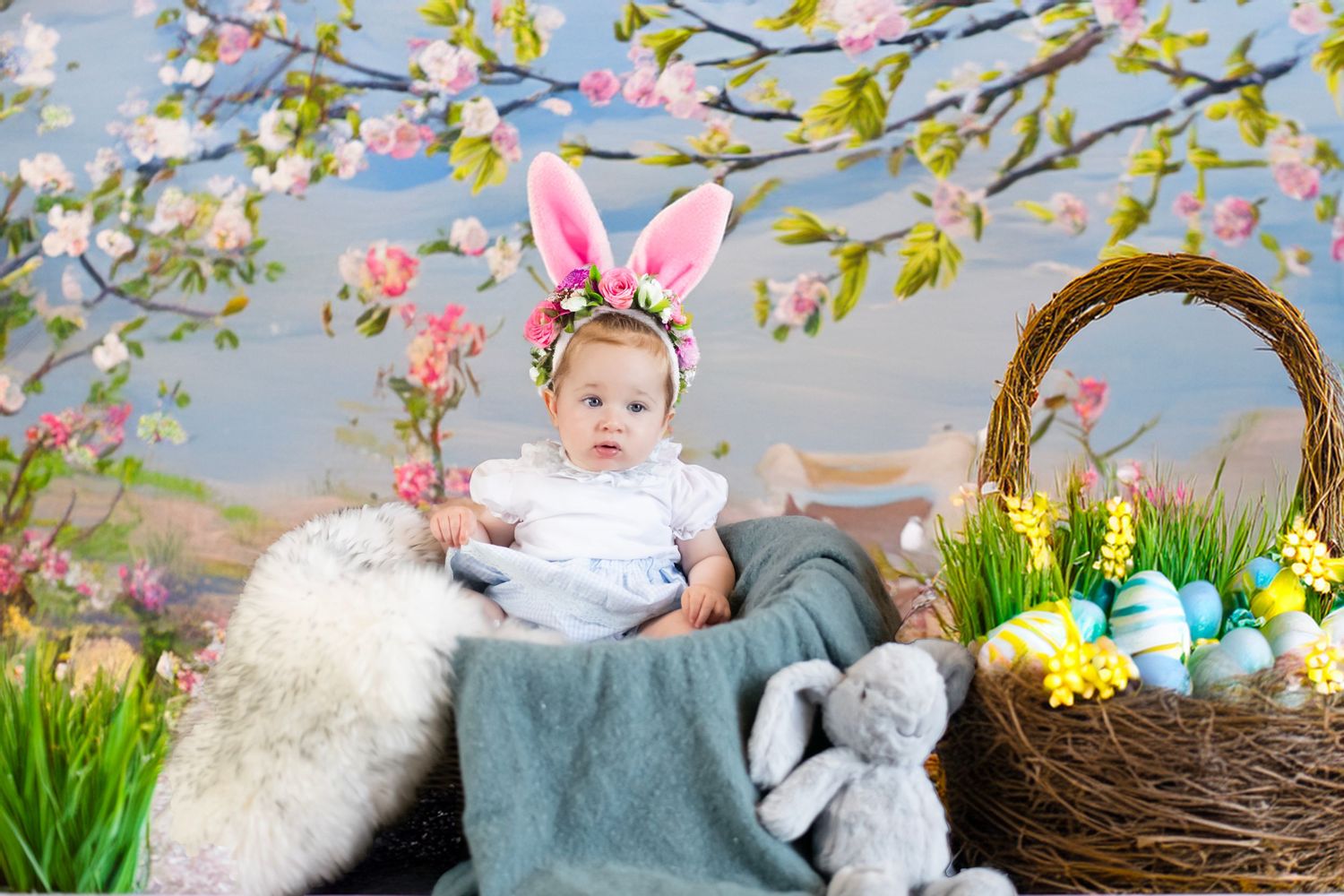Easter basket and spring blossoms frame a dreamy scene with bunny ears and soft plush decorations.