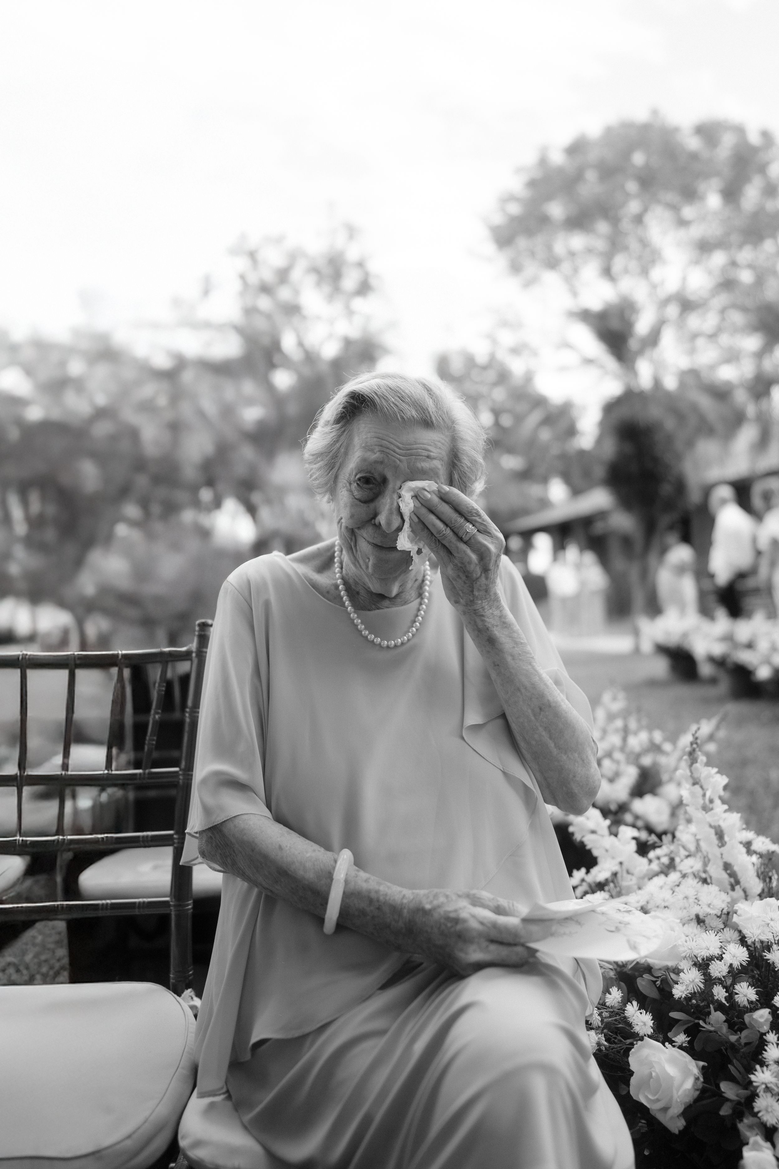 Emotional moment captured during outdoor wedding ceremony with floral decorations.