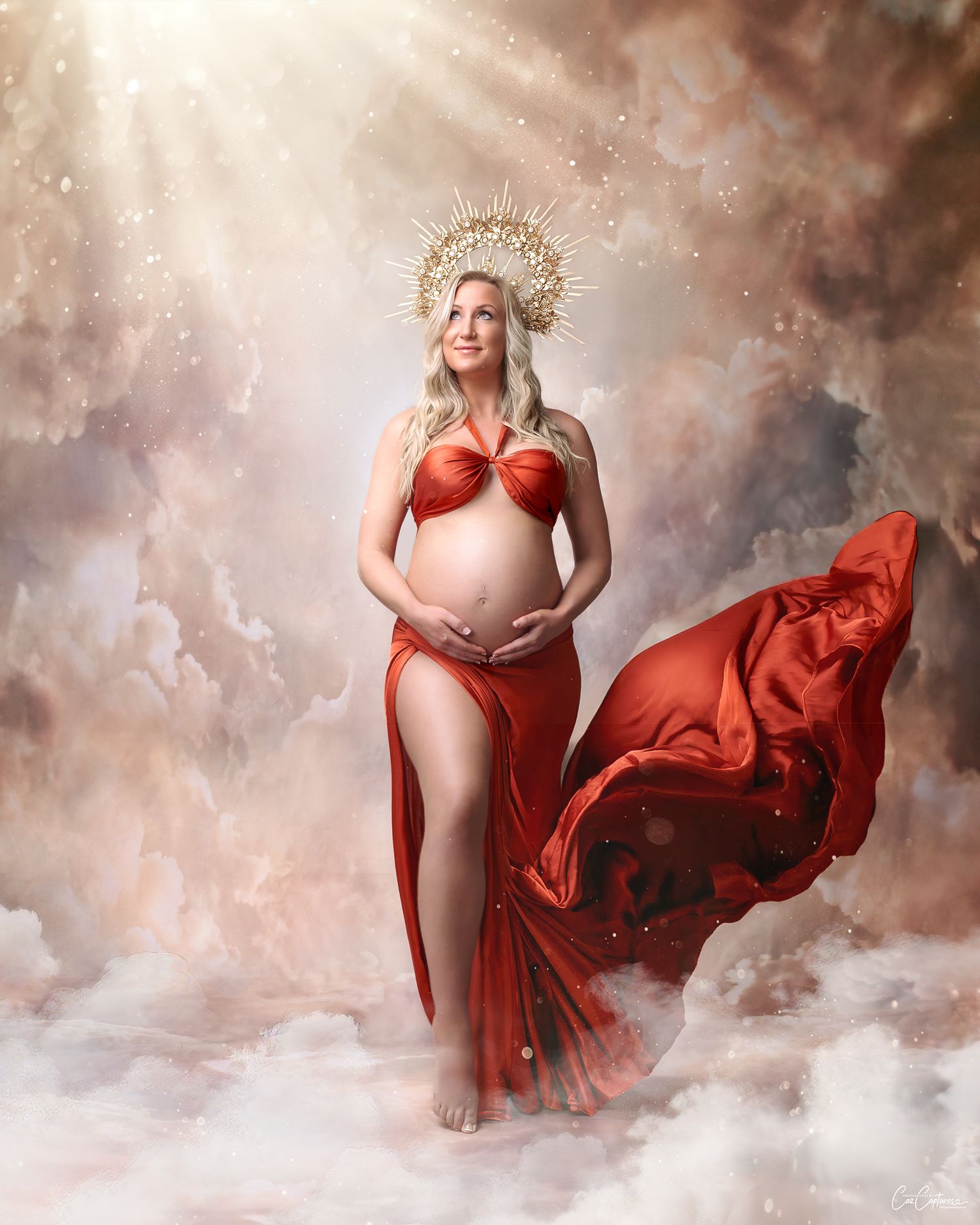 Sydney maternity: mum in a rust silk hater top and silk skirt and crystal crown, dramatically posed against a cloudy, digital sky backdrop.