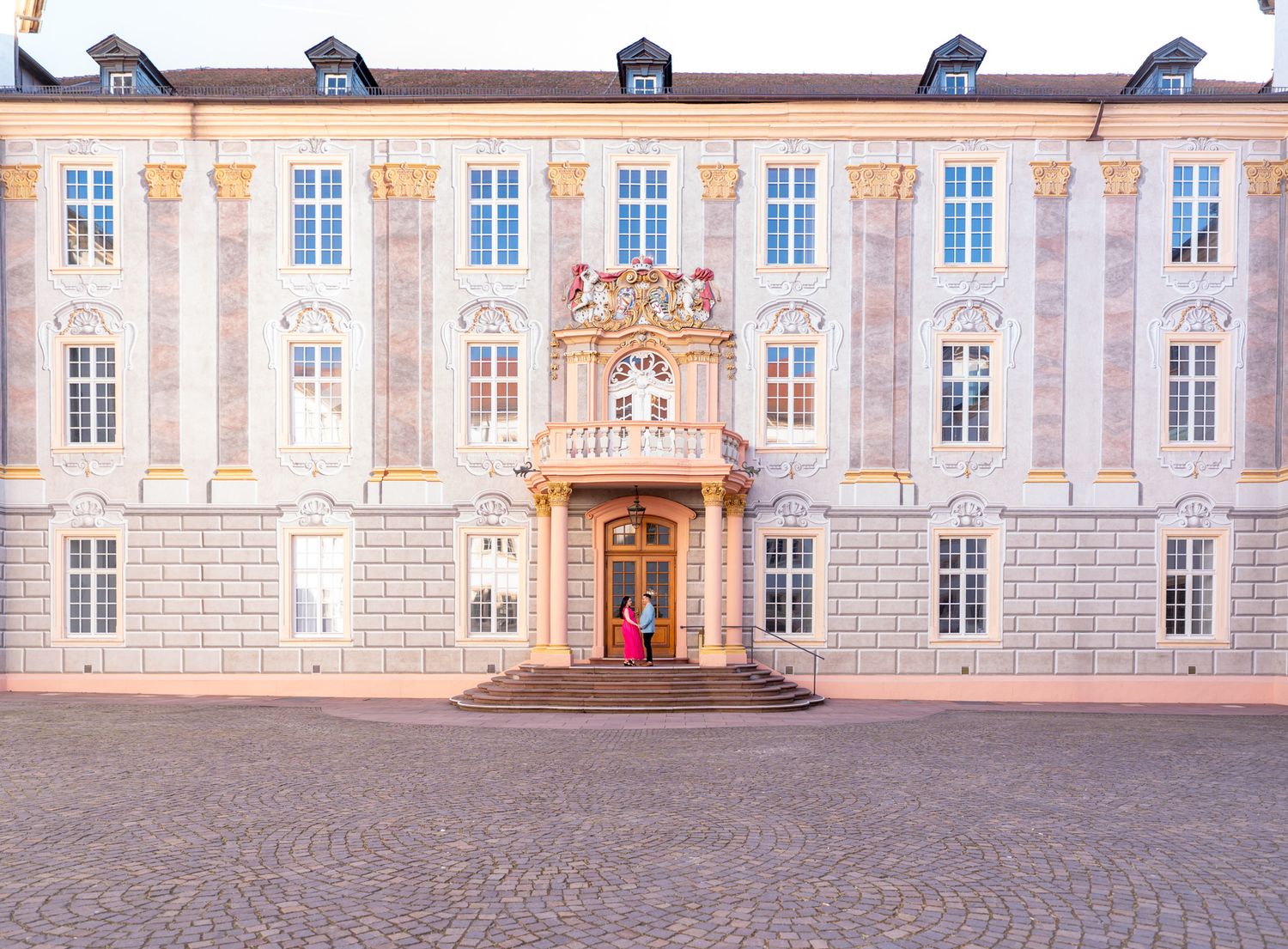 Hochzeitspaar beim Fotoshooting hinter dem Standesamt Ettlingen mit Blick auf das Schloss – romantisch & historisch.