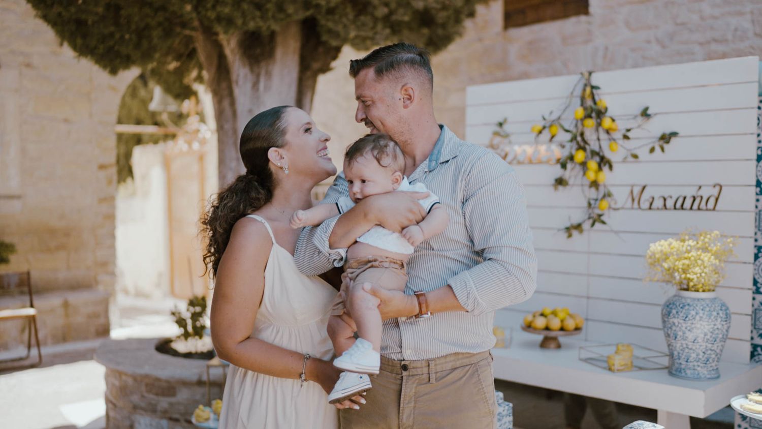 A loving family shares a tender moment together at an outdoor venue with flower decorations.