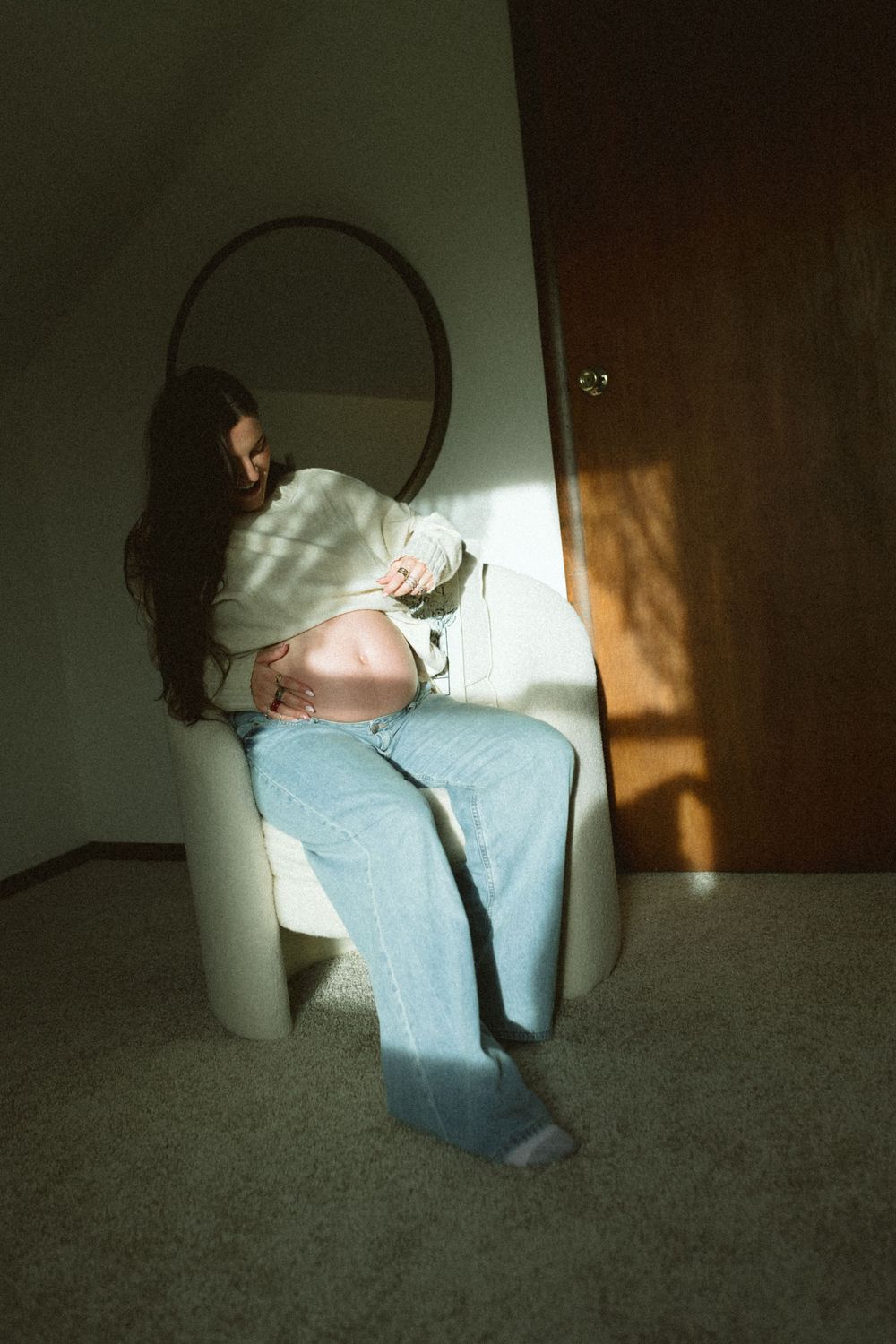 A sequence of dark moody photos showing a person in light clothing sitting against a wall with dramatic shadows.