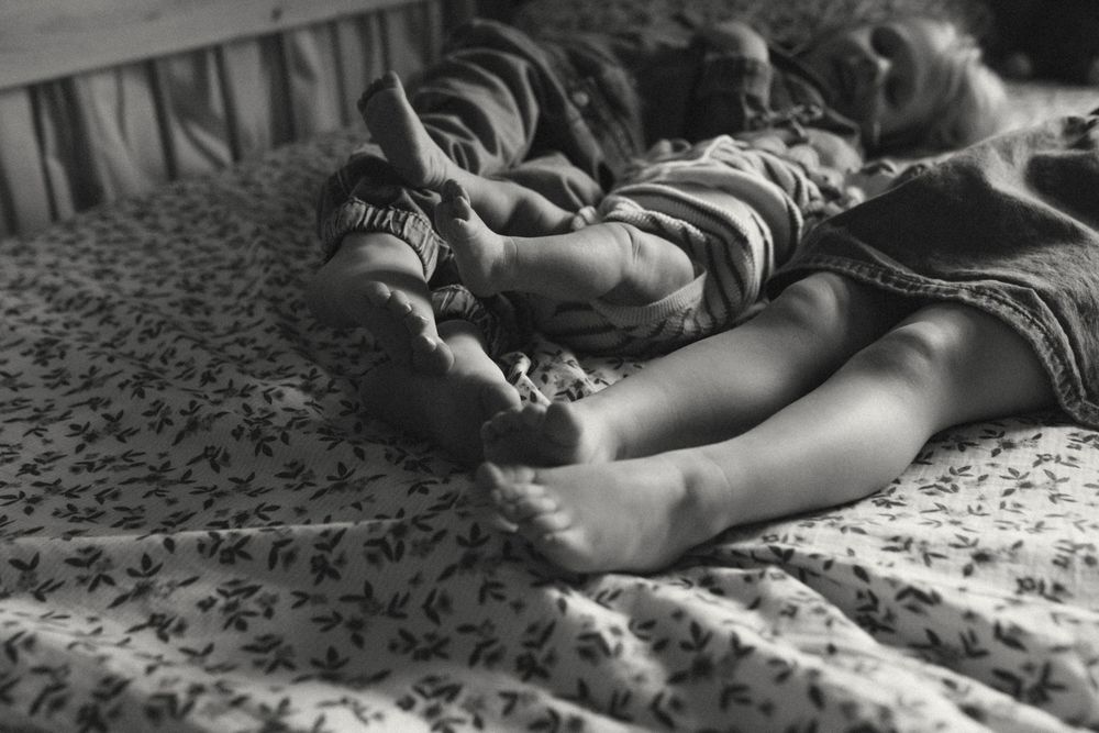 Black and white film strip showing a figure lying on a textured surface in various dramatic poses.