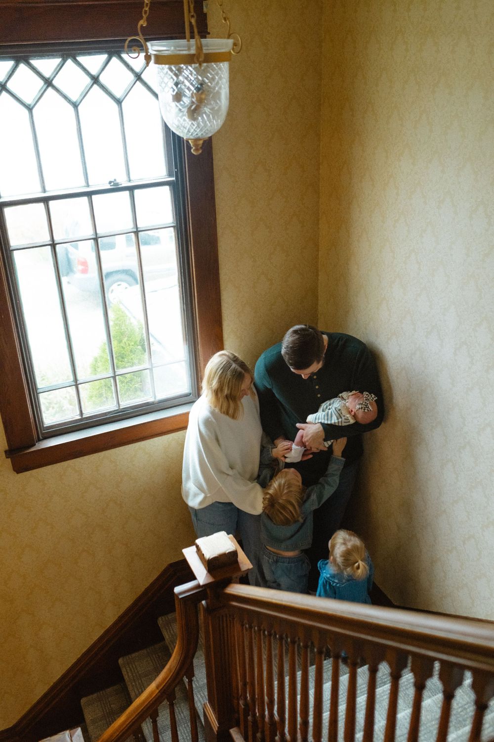 A sequence of photos showing someone cleaning a stairwell window using a cloth and spray bottle.