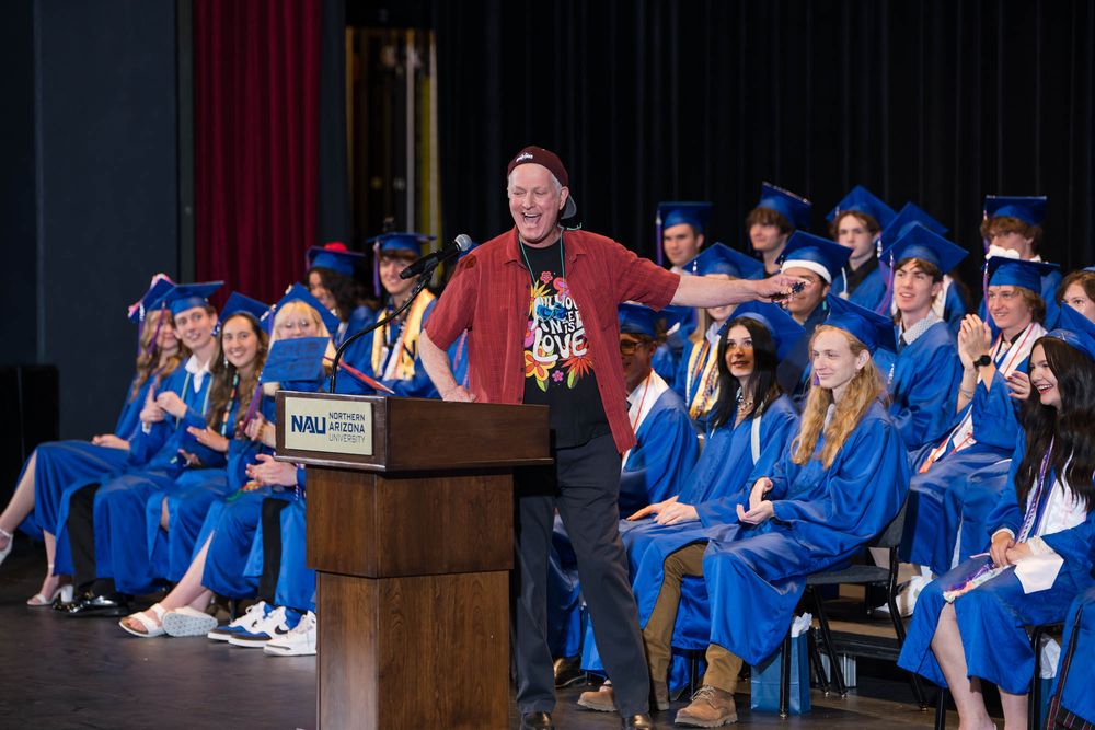Retiring Principal Litwicki in t-shirt and backwards cap speaks to graduates, embracing 'senioritis' during his final NPA graduation.