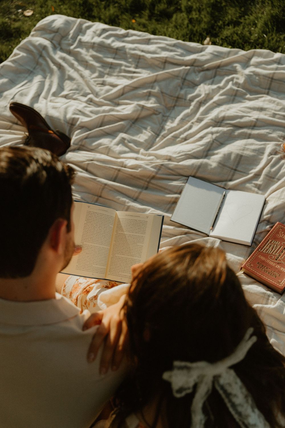 Books spread out on a white blanket in natural lighting.