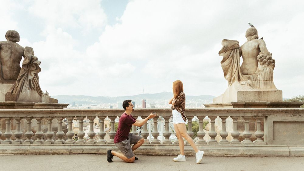 Stone balustrade and classical architecture create romantic setting for couple.