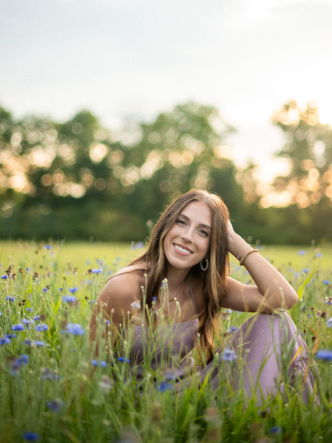 A series of outdoor portrait photos taken in a wildflower meadow with blue cornflowers at golden hour sunset.