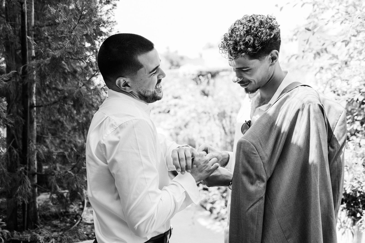 Two people engaged in an animated conversation outdoors in black and white photography.