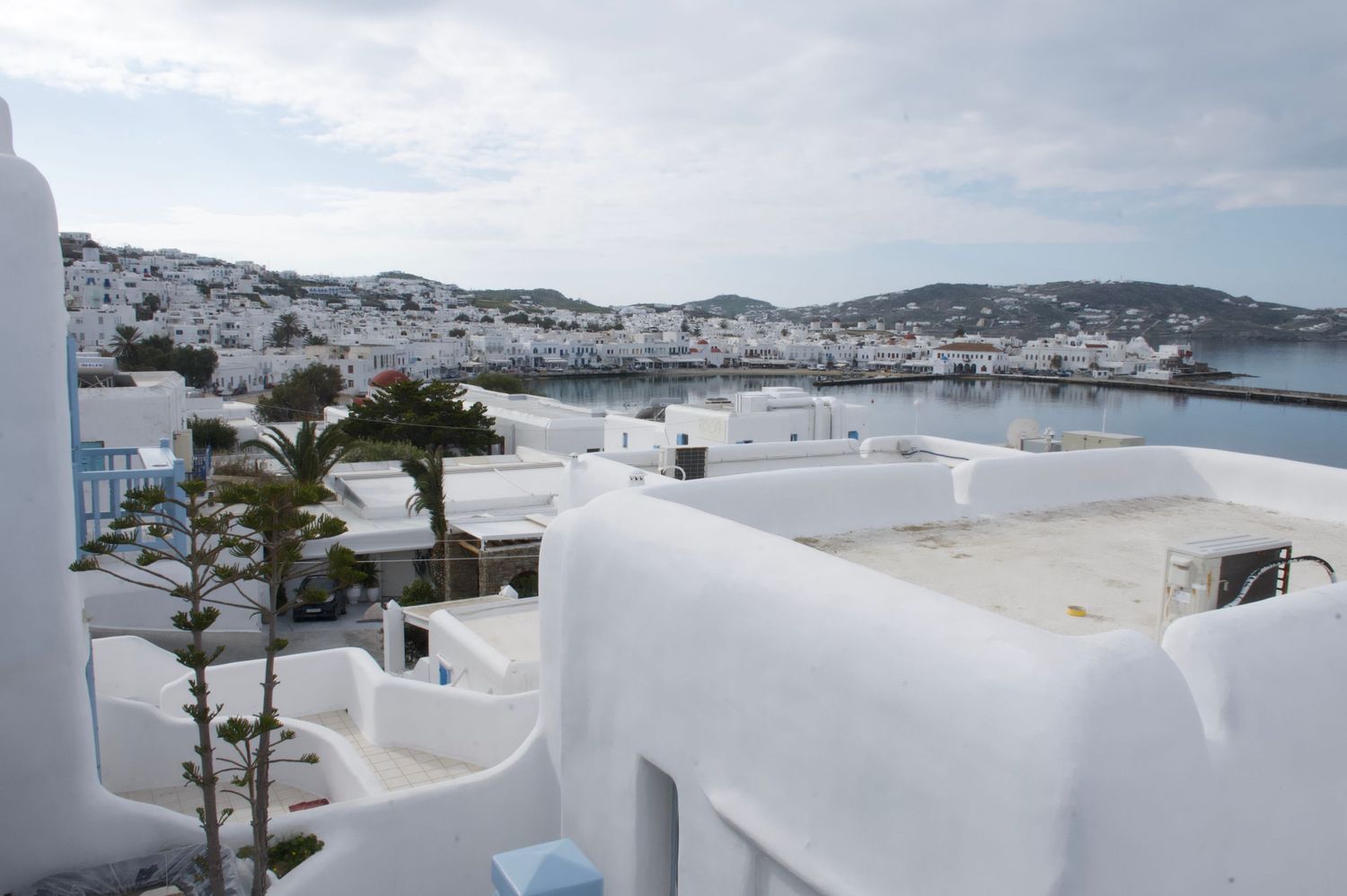 Panoramic view of white-washed buildings and narrow streets in Mykonos, Greece overlooking the Aegean Sea.