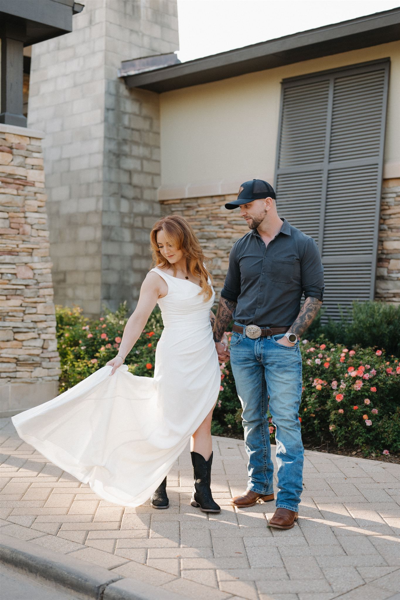 A couple dances on a stone patio with the woman's white dress flowing gracefully in a sequence of romantic poses.