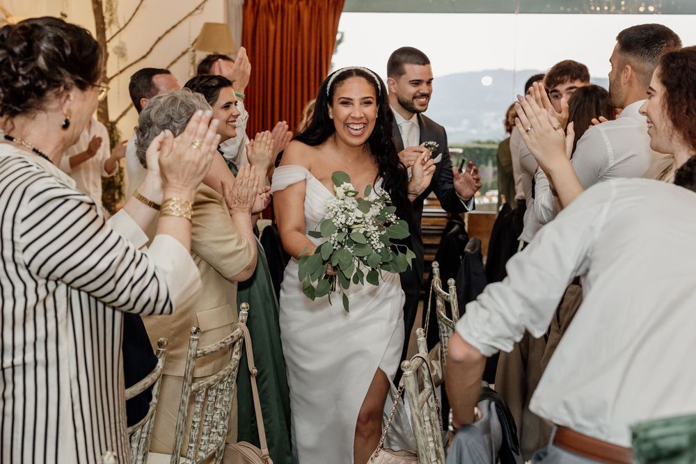 Wedding guests gather in celebration, embracing and sharing joyful moments at an elegant indoor reception.