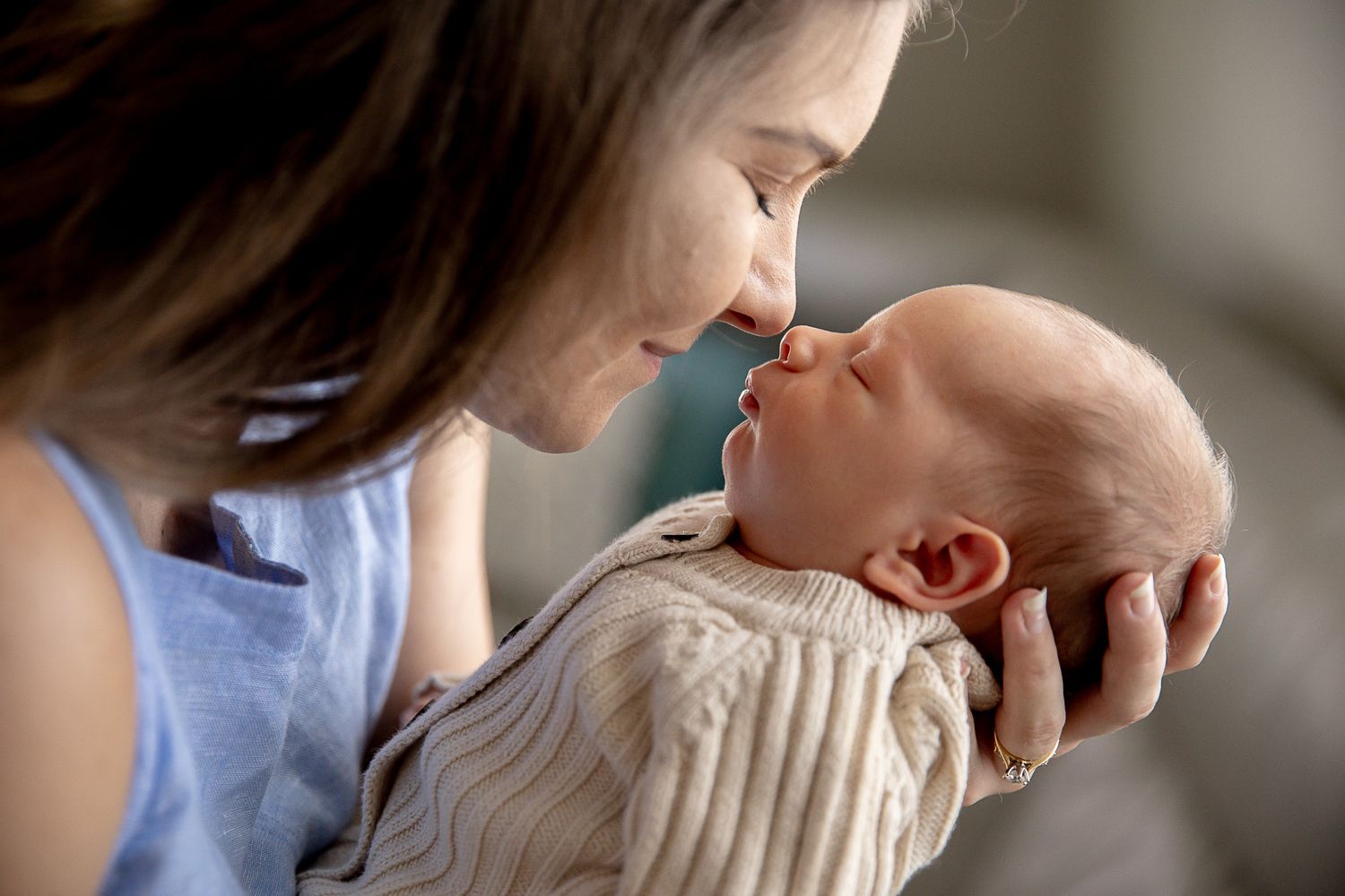 Mother and new born touching noses at new born professional photo shoot