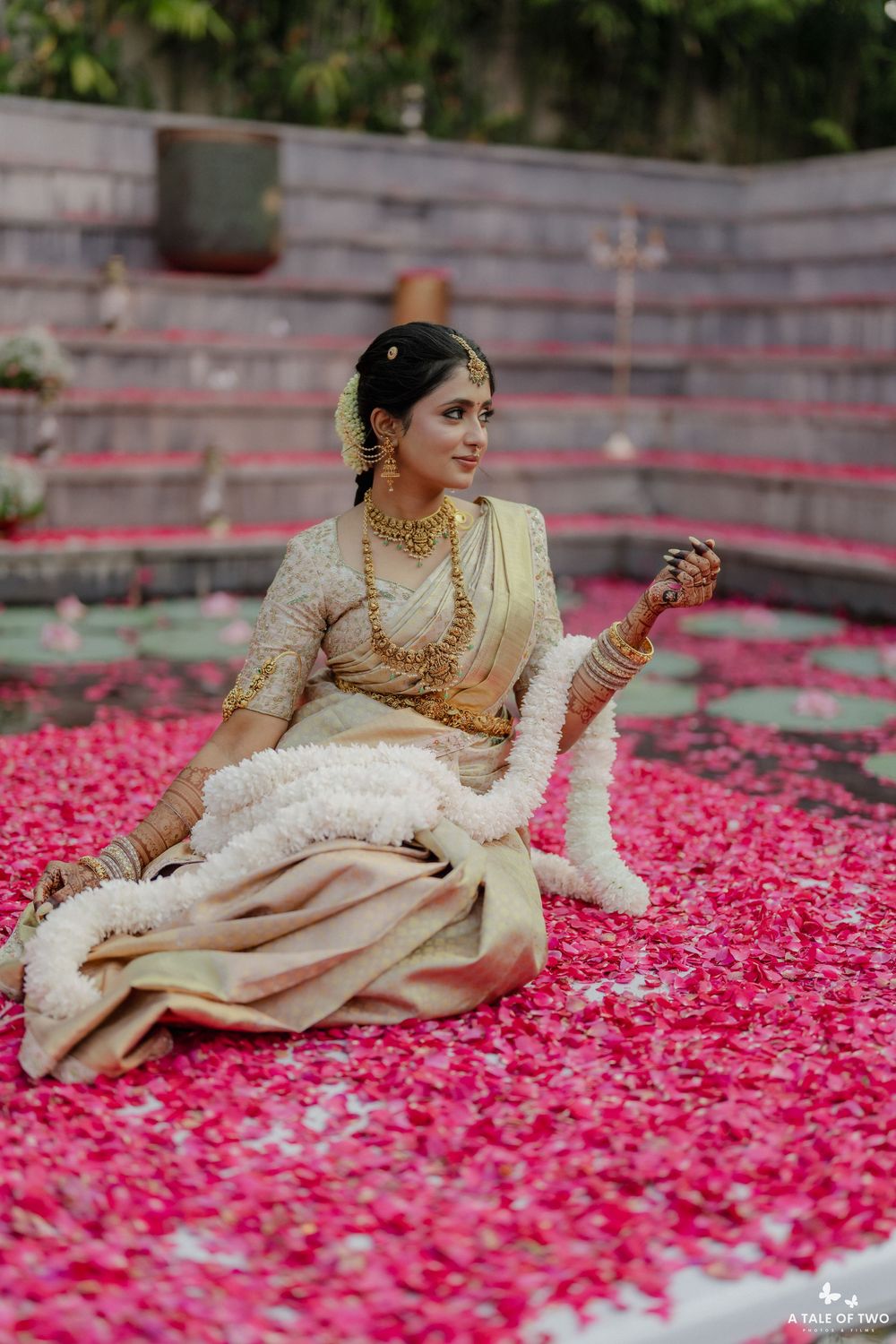 Traditional South Indian bridal portrait amidst scattered pink rose petals.
