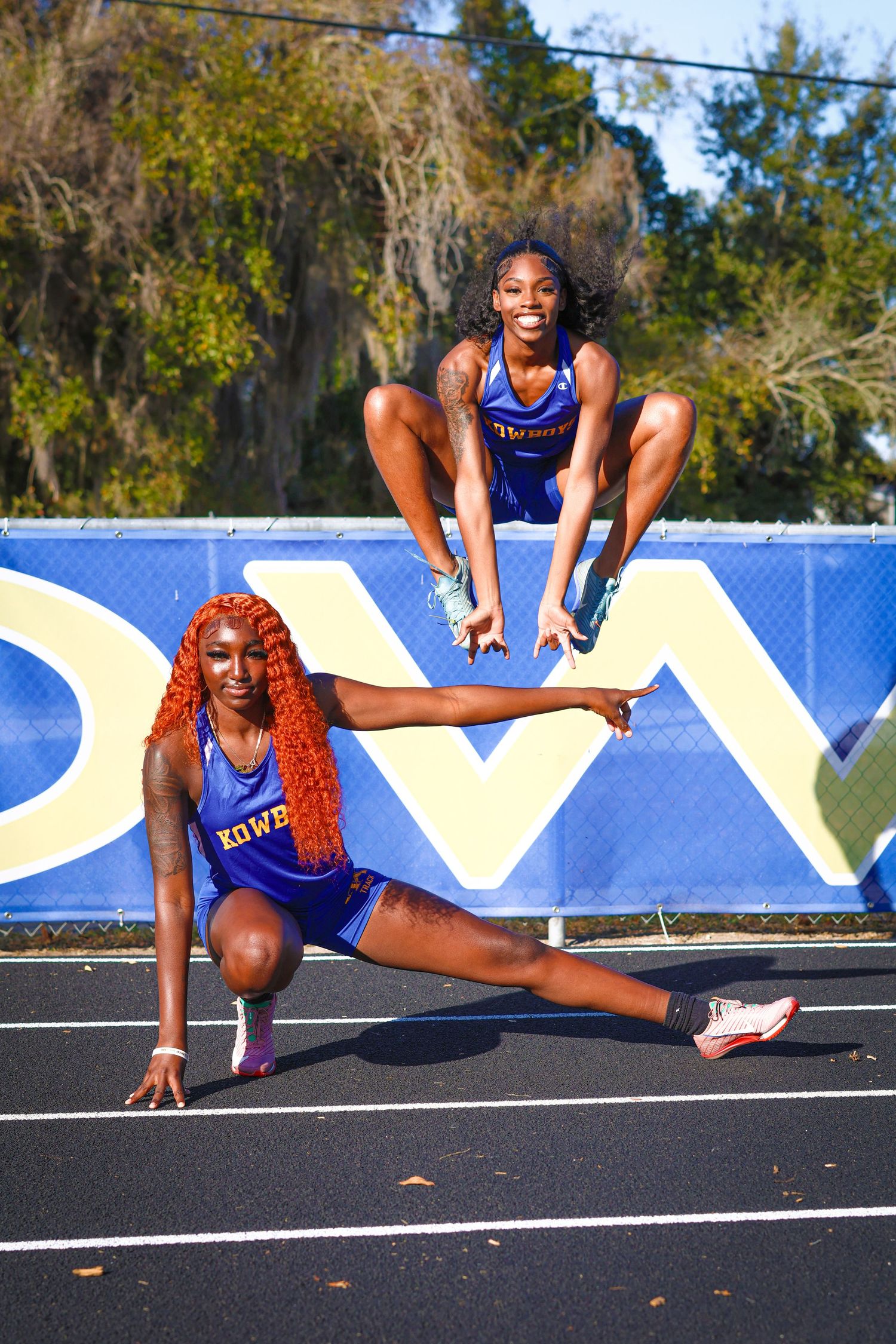 Athlete in blue uniform performs dynamic stretching exercises on outdoor track surface in sequence of poses.