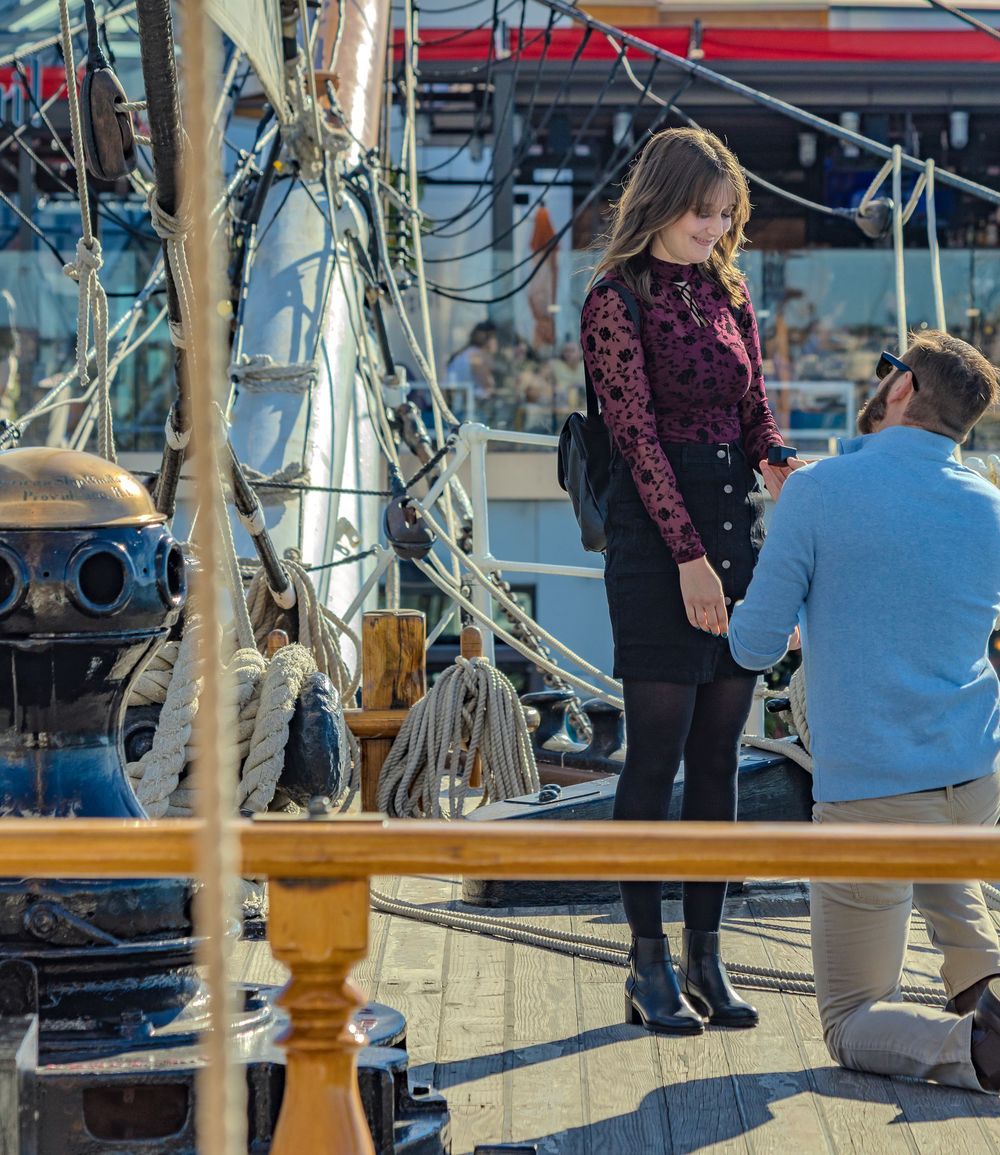 Engaged couple exploring a tall ship deck during a Valentine's session by Zeus Holbrook Wedding Photographer