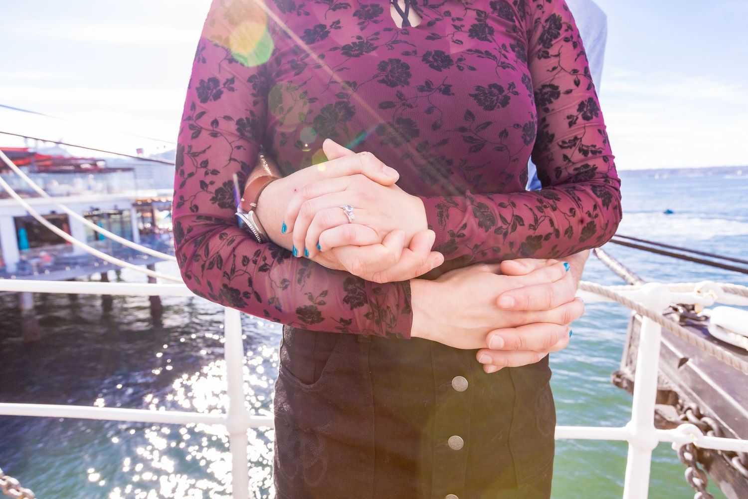Close-up of couple holding hands with engagement ring by the ocean captured by Zeus Holbrook Wedding Photographer