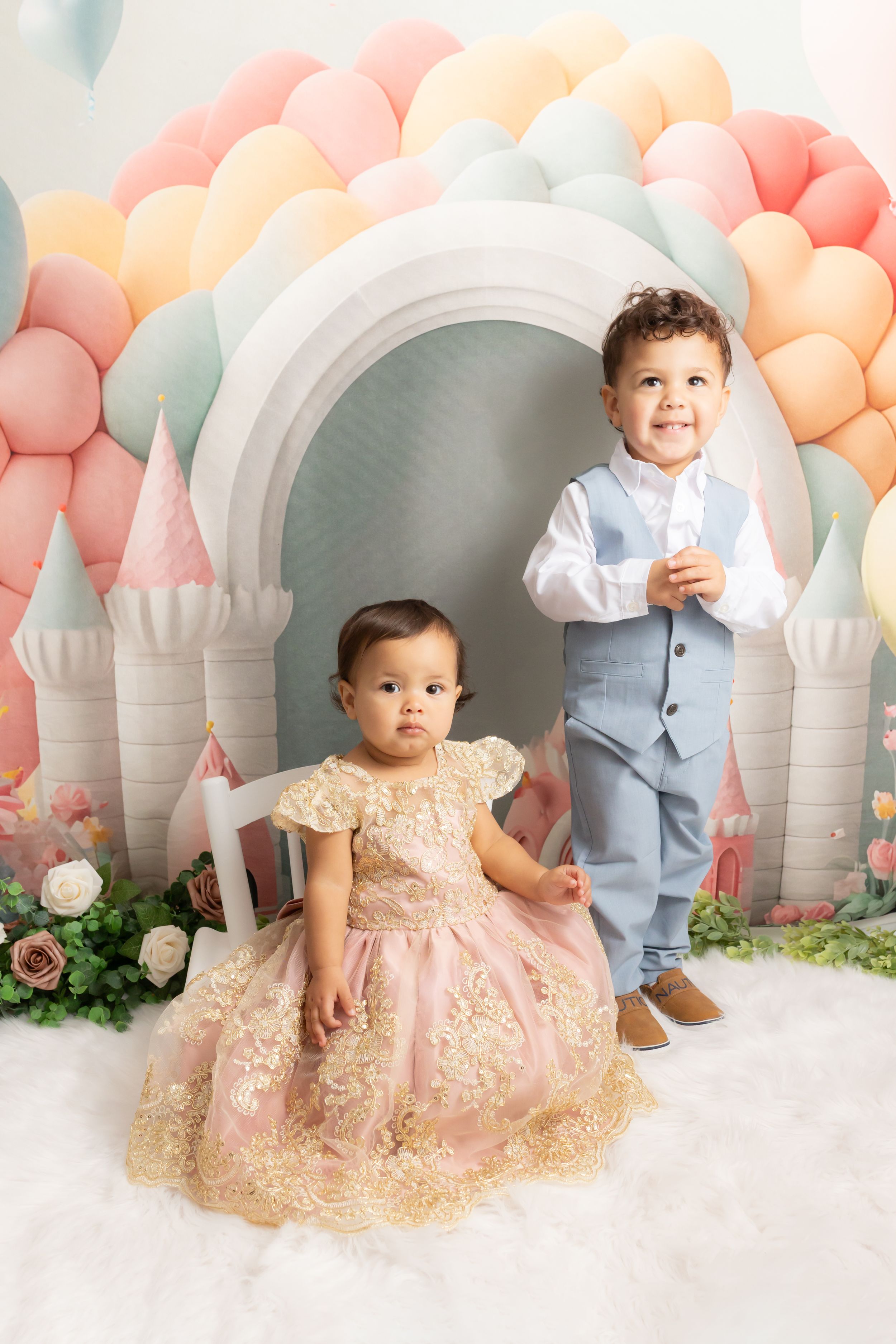 Timeless studio portrait of two young siblings ages one and two sitting together on a neutral background in Swansboro, North Carolina