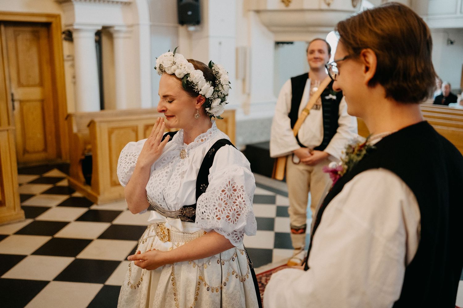 A series of black and white wedding photos showing candid moments during a celebration at a venue with checkered floors.