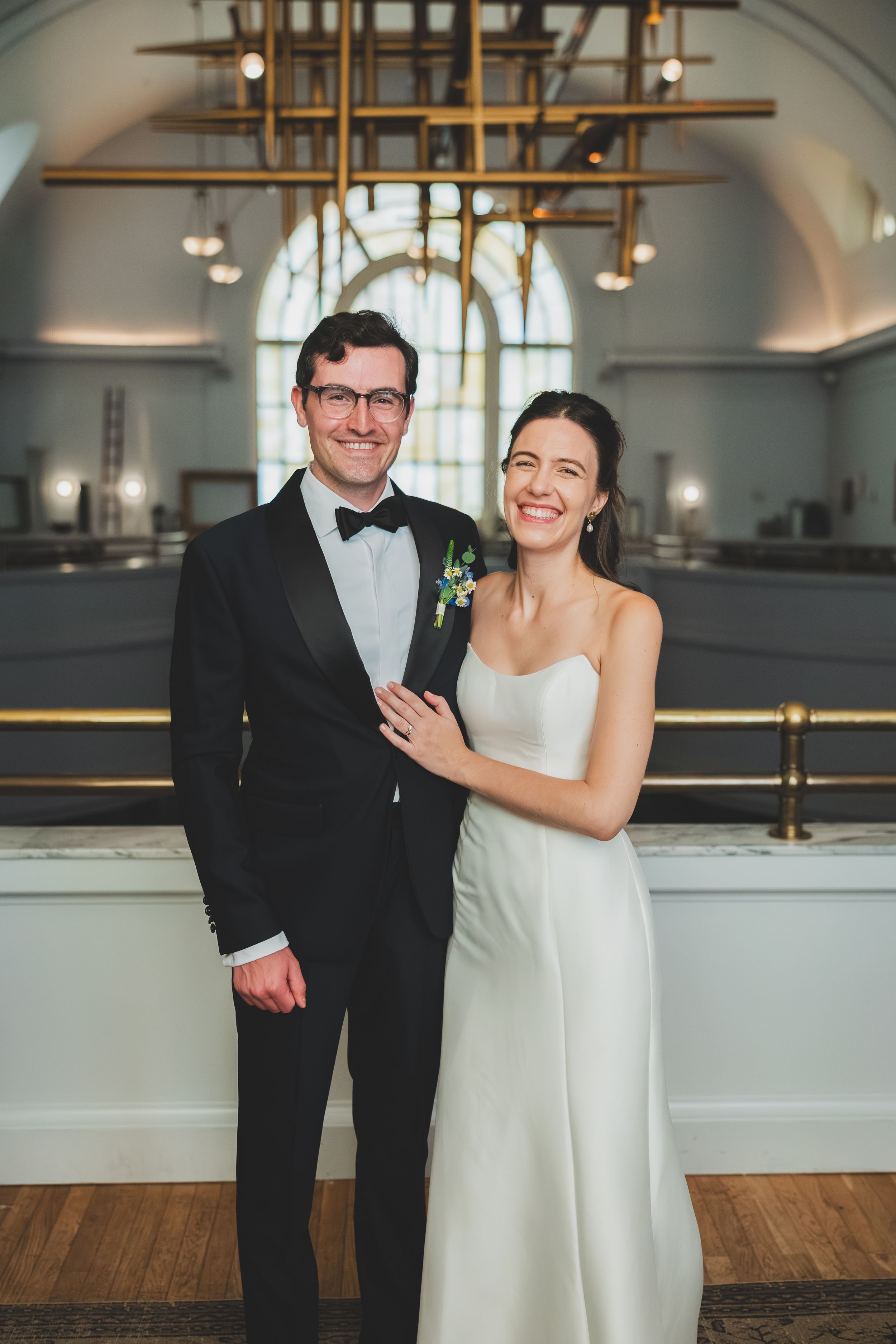 A happy couple shares joyful moments in the line DC, an elegant indoor venue with wooden floors and hanging lights.