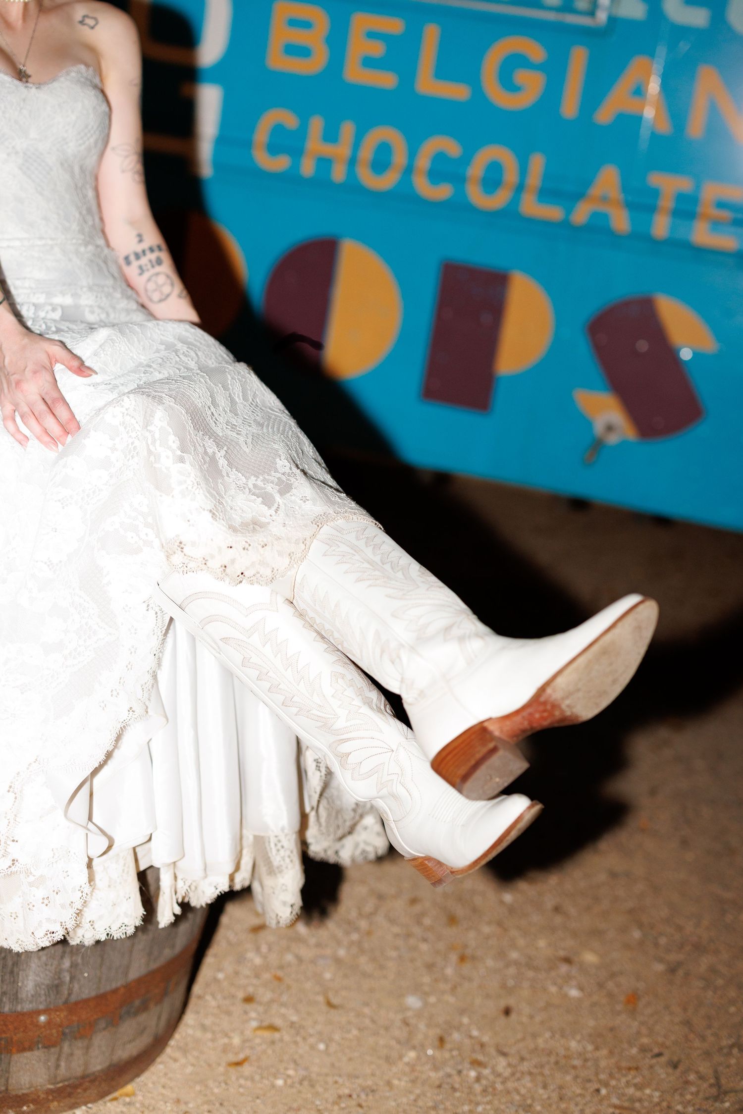 A close-up view of a white ruffled dress against a blue background with text about Belgian chocolate.