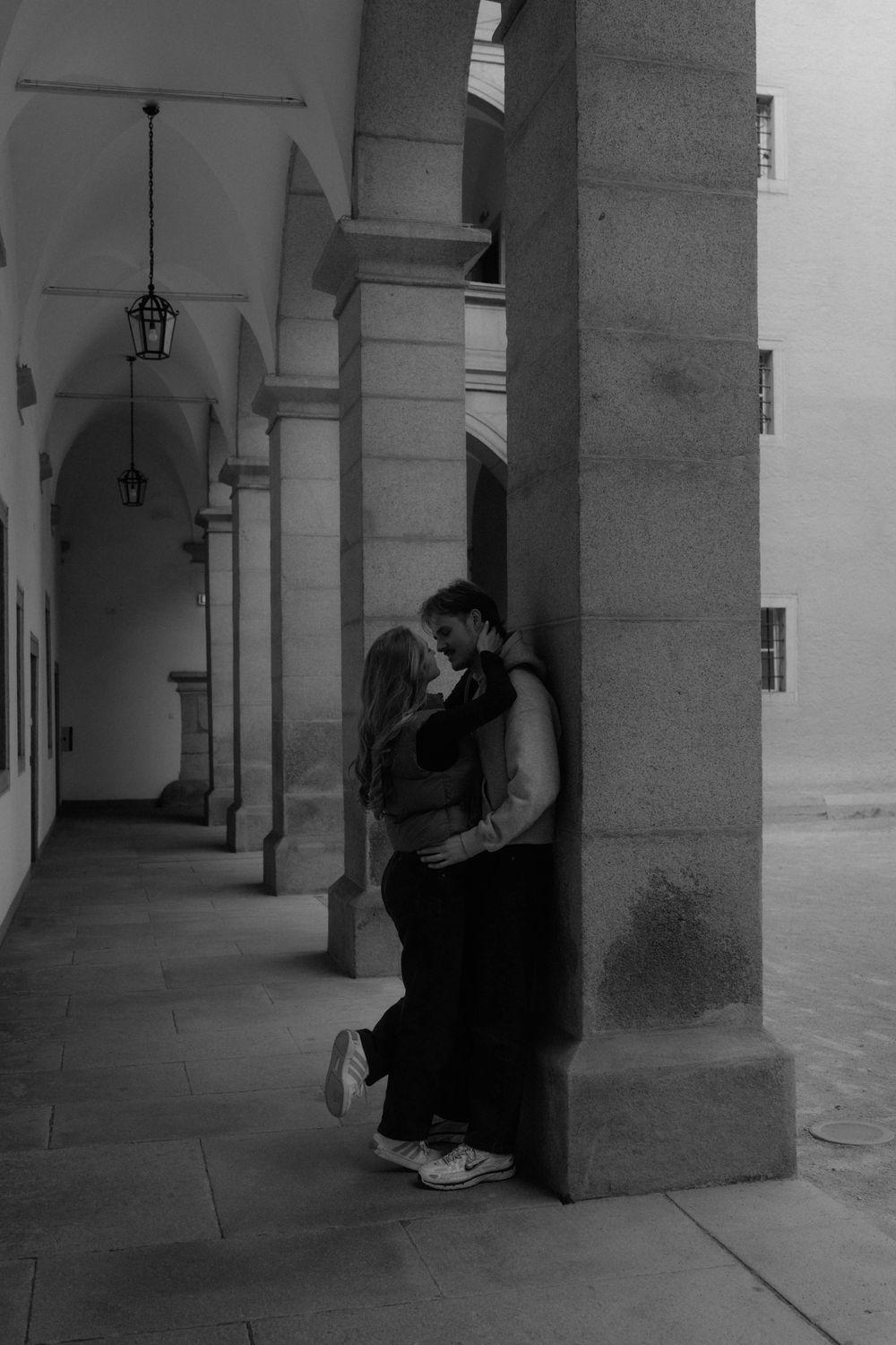 A black and white photo sequence shows a person sitting alone in a columned corridor, creating a moody atmosphere.