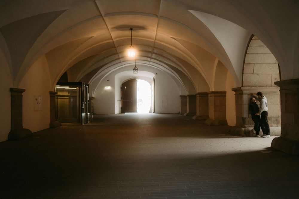 Dimly lit underground tunnel with arched ceiling and stone walls creates an atmospheric corridor.