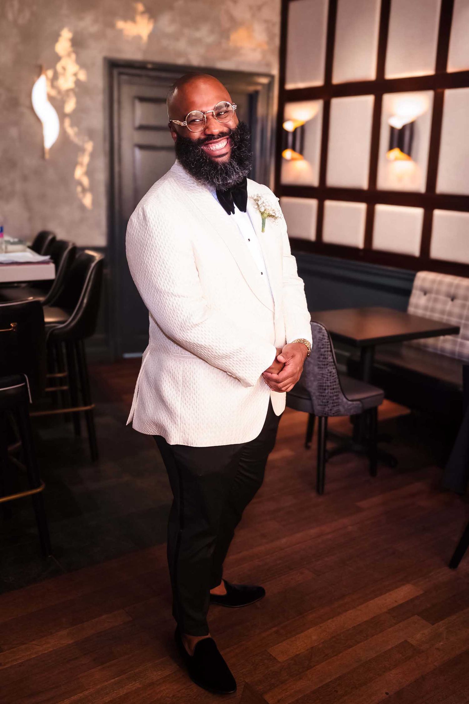 Groom smiling during first look in The Irving tavern at Lenox Hotel Boston after seeing bride for the first time