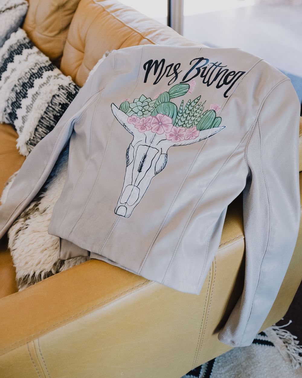 Custom white leather bridal jacket with Mrs. Butner and desert floral skull design on back.