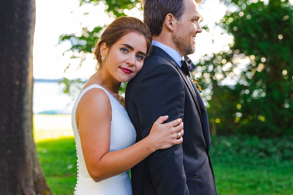 A couple embracing in a scenic outdoor setting with lush greenery.