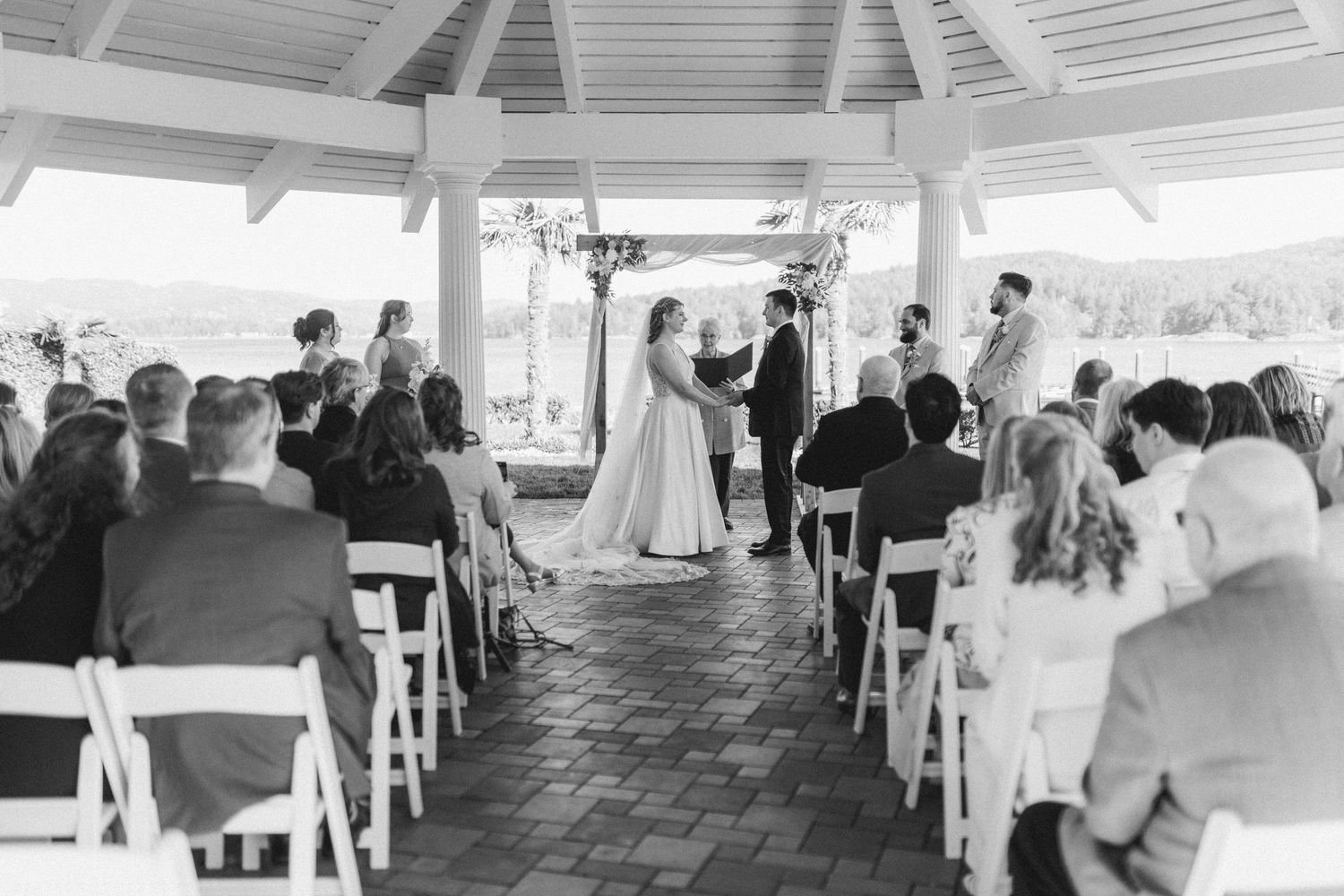 Elegant outdoor wedding ceremony under pavilion with seated guests.