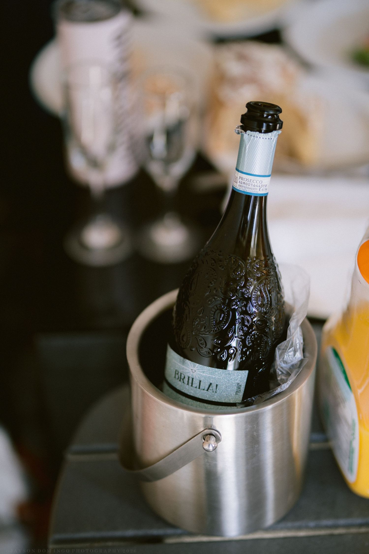 Bottle of Brilla prosecco chilling in a stainless steel ice bucket at a wedding reception.