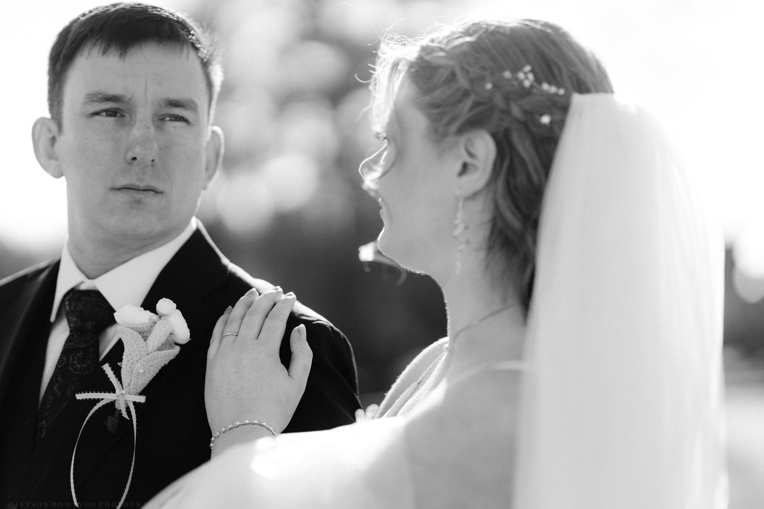 Black and white portrait of bride and groom at wedding ceremony.