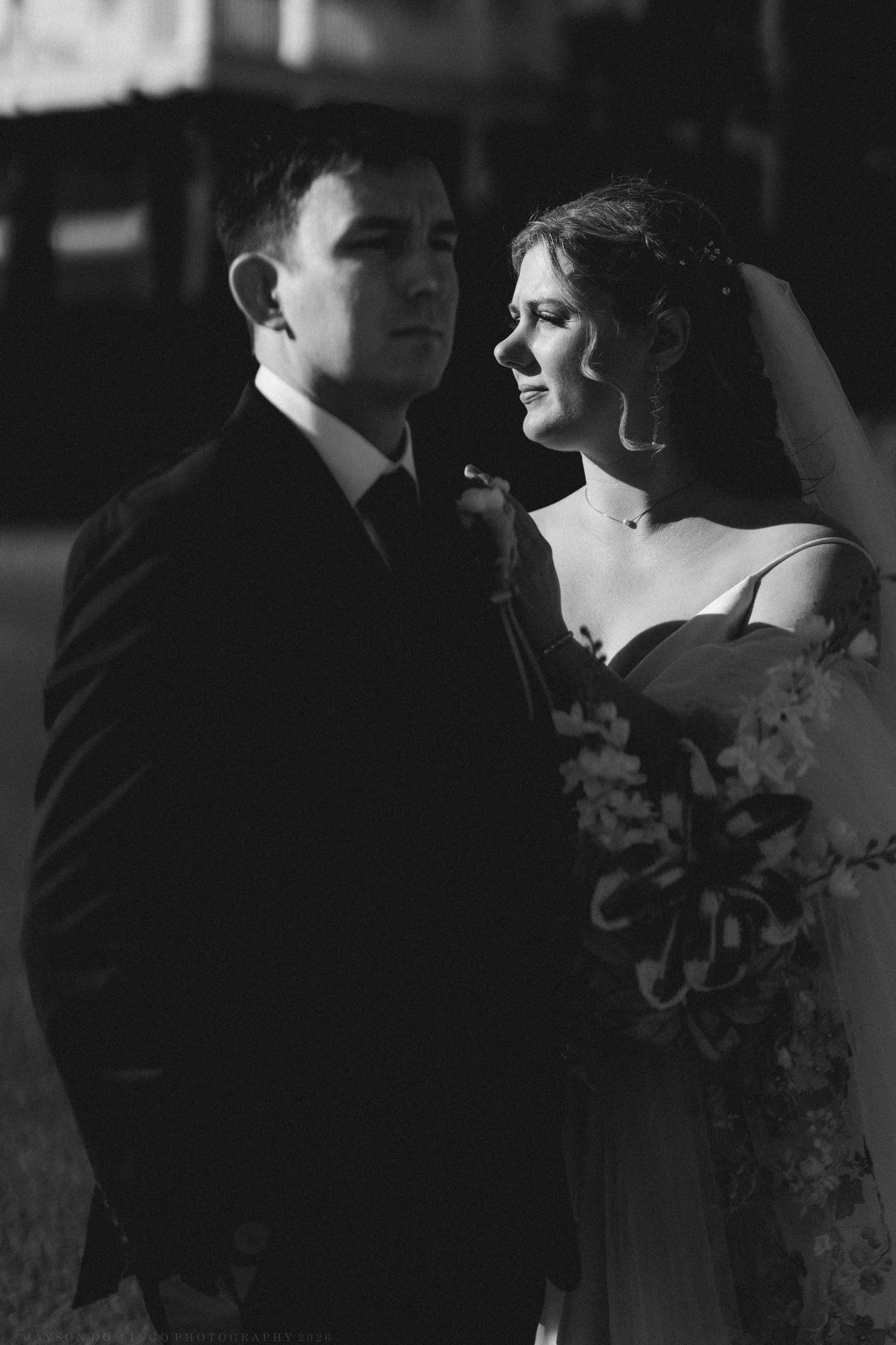 Elegant black and white portrait of bride and groom at night.
